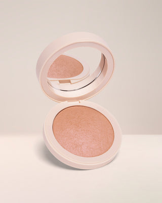 Open compact of EM Cosmetics Heaven's Glow Radiant Veil Blush in Baroque, a warm bronzy nude shade, showing the marbled, satin powder texture.