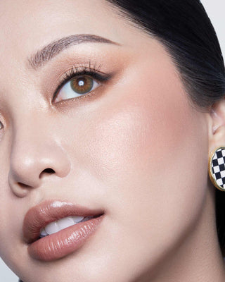 Michelle Phan wearing EM Cosmetics Heaven's Glow Blush in Baroque, creating a healthy, radiant peachy coral flush.